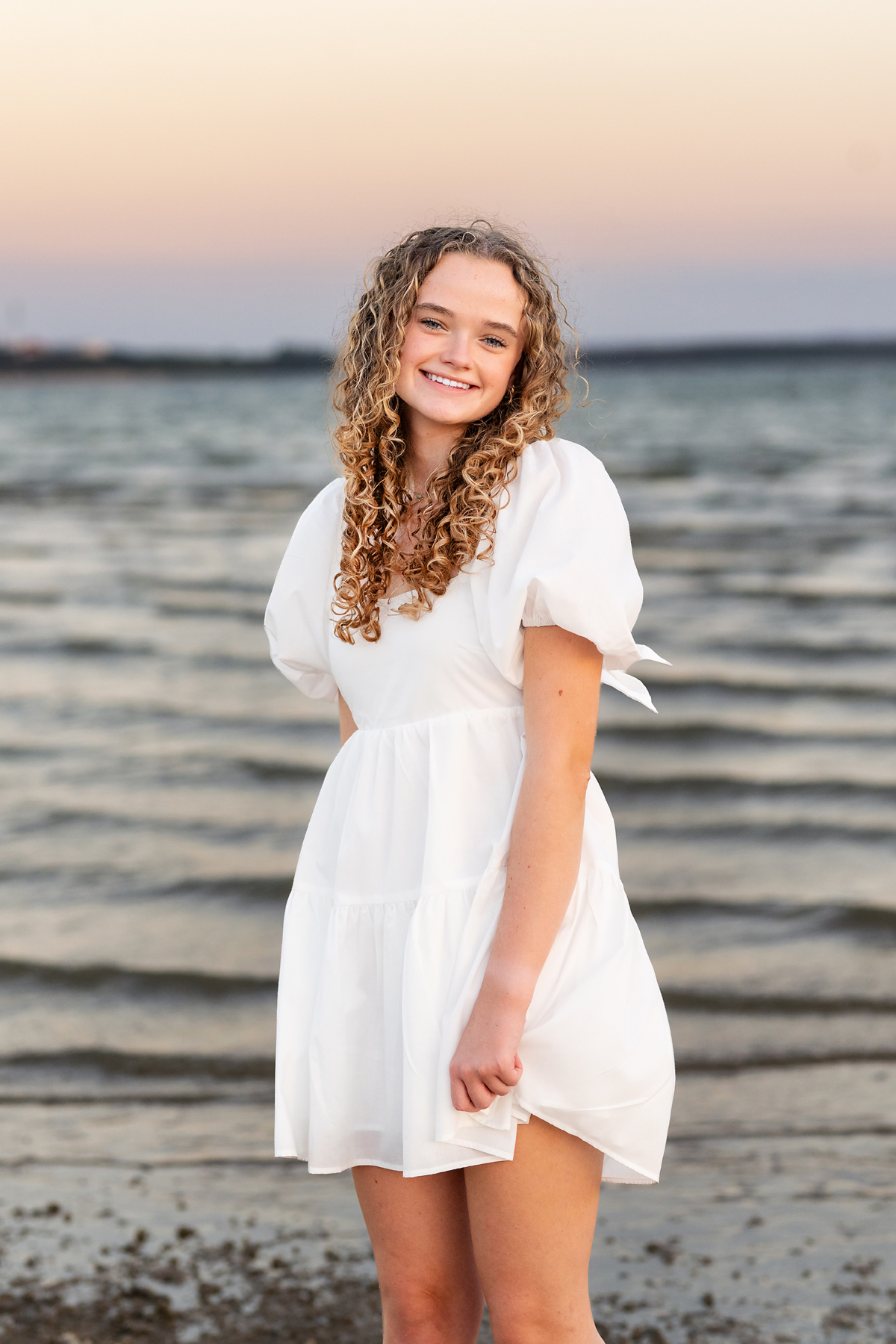 Senior girl in white dress posing for beach senior portraits by Paige Walker Photography