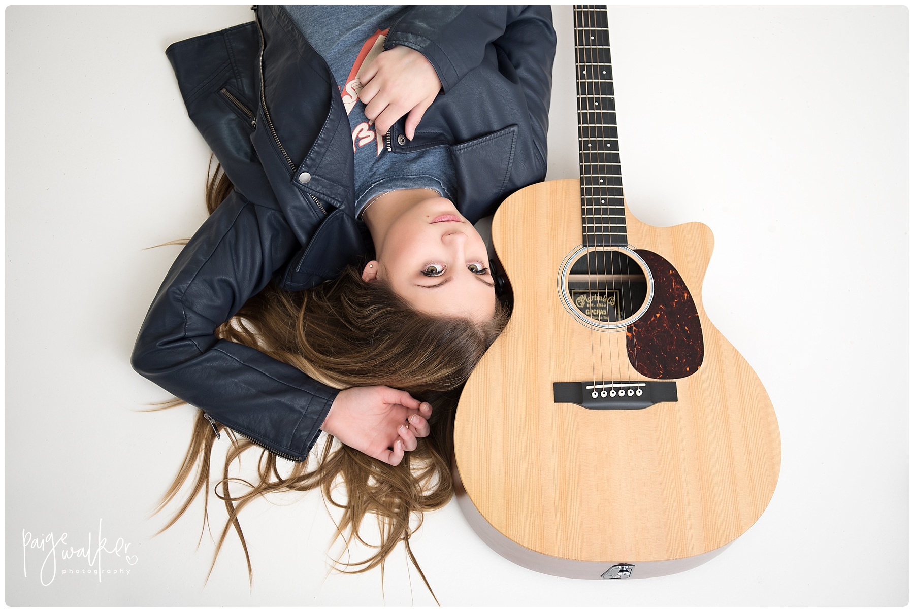 teenage laying with her guitar