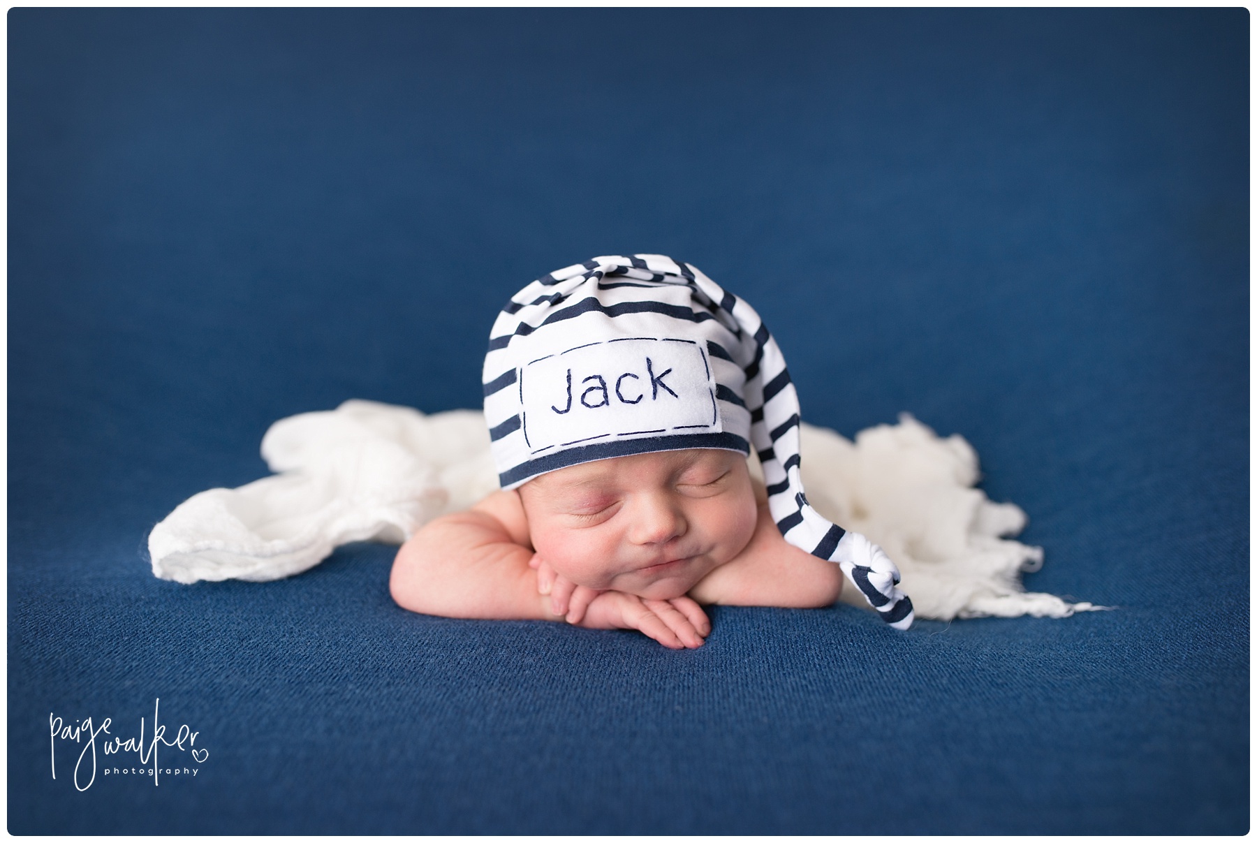 Jack laying on his hands on a navy blanket