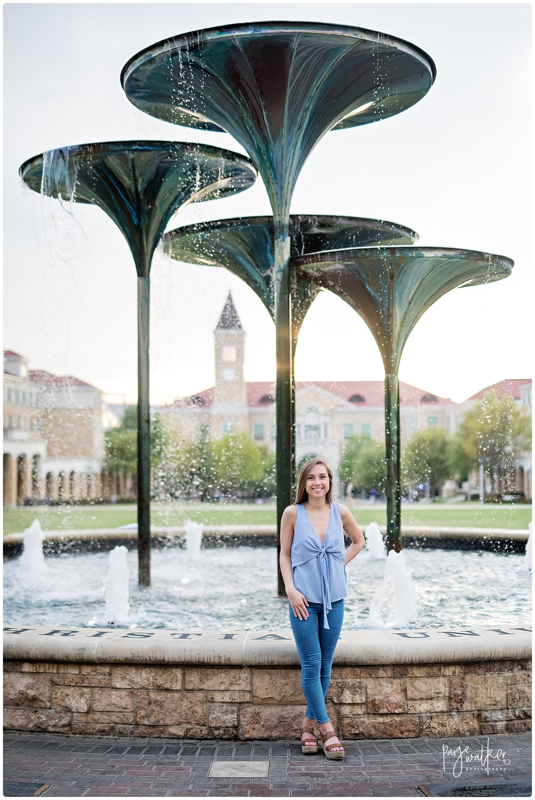 senior graduate in front of frog fountain