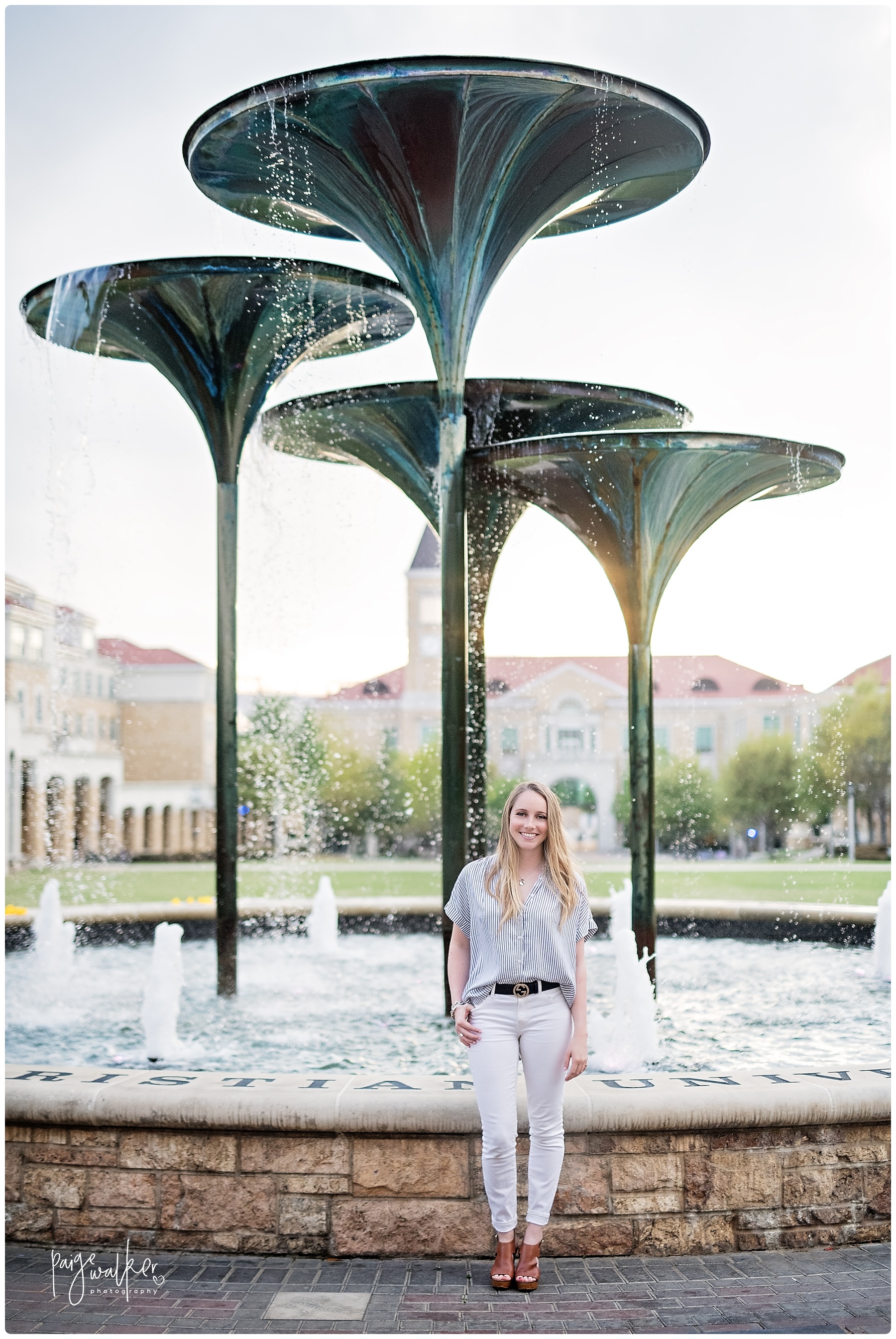 TCU senior standing in front of frog fountain