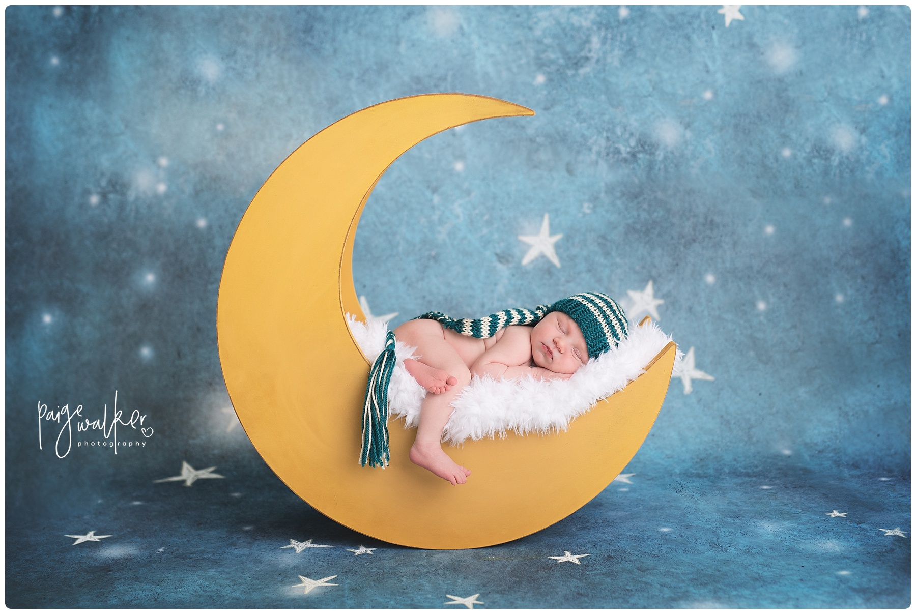newborn boy laying on a moon