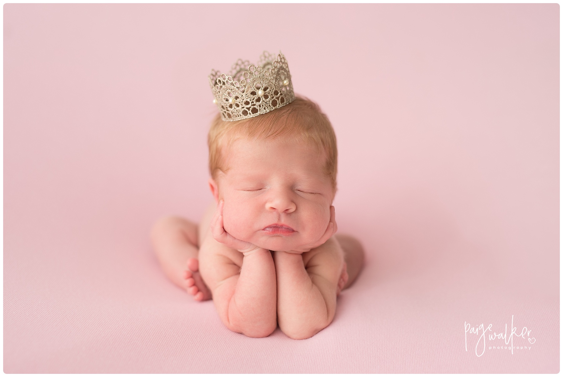 newborn girl in the froggy pose with a crown on