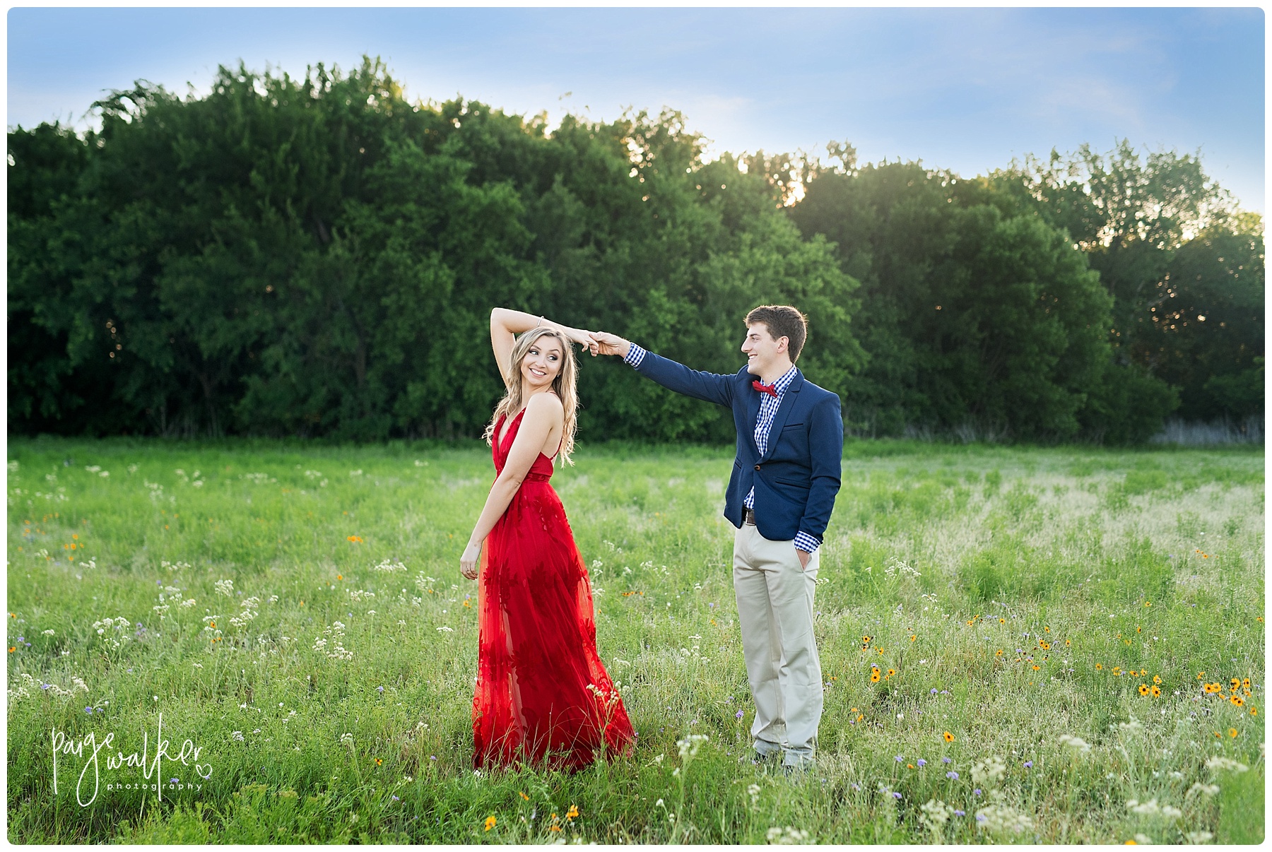 engaged couple dancing in a field