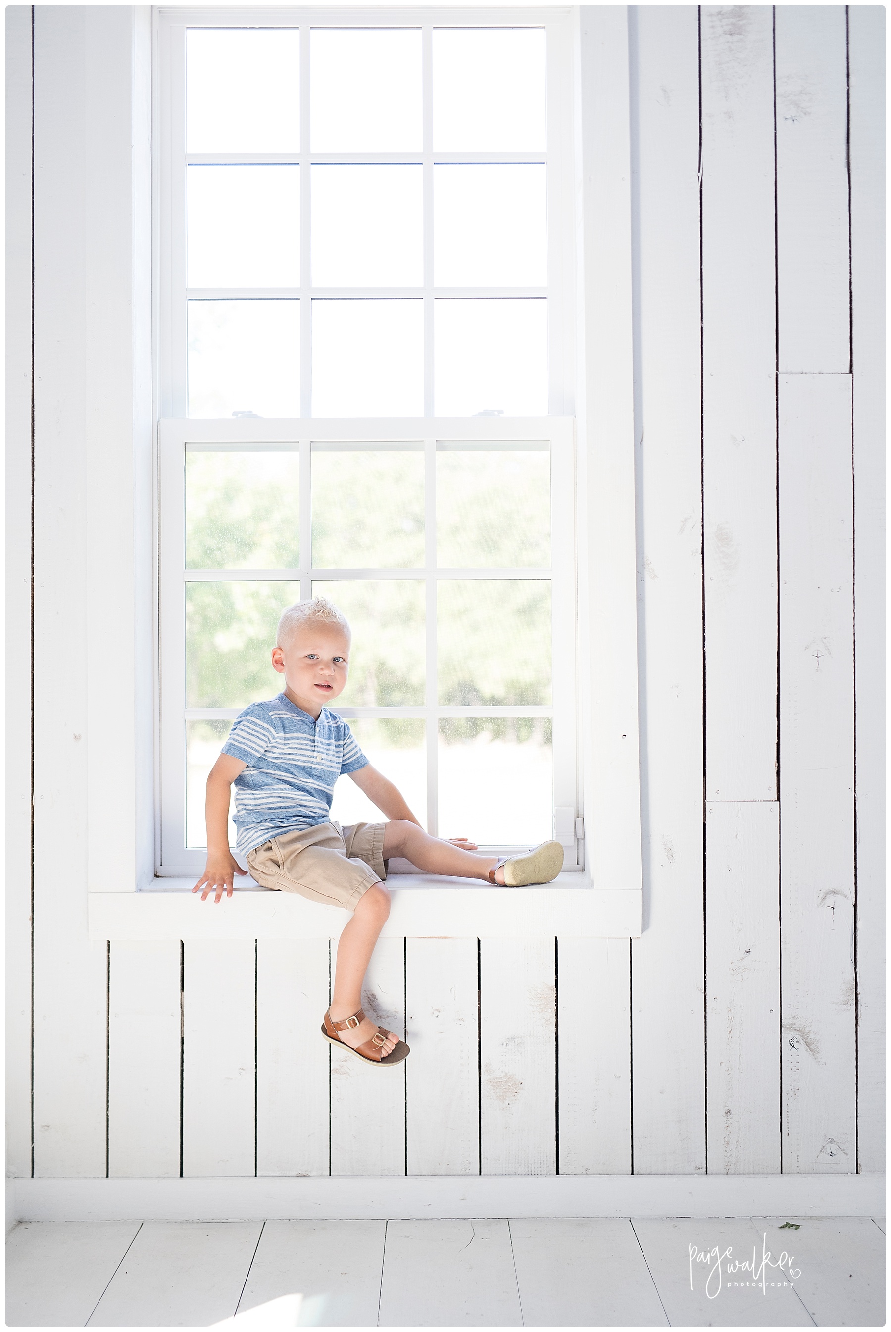 little boy sitting in a window