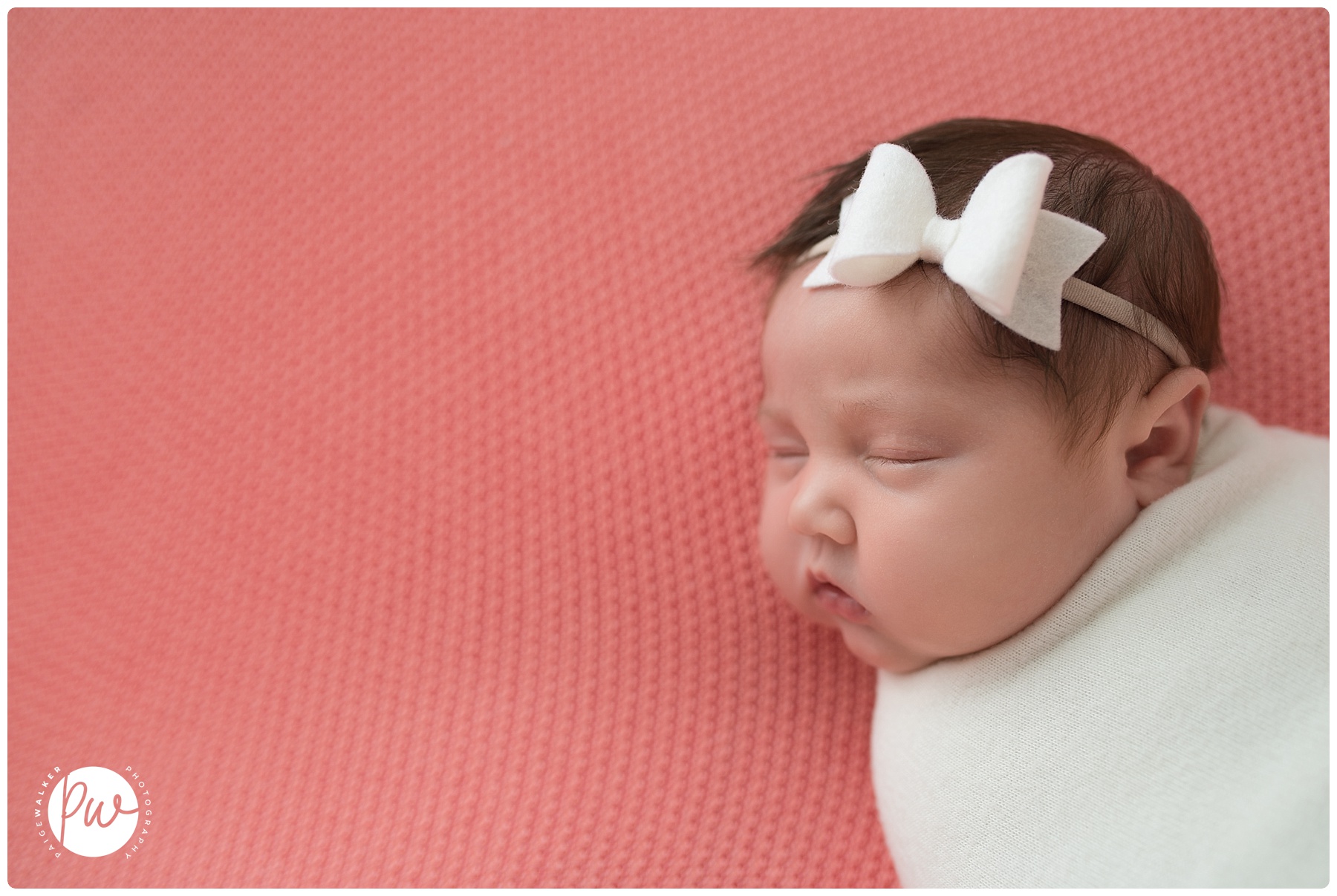 newborn girl laying on pink