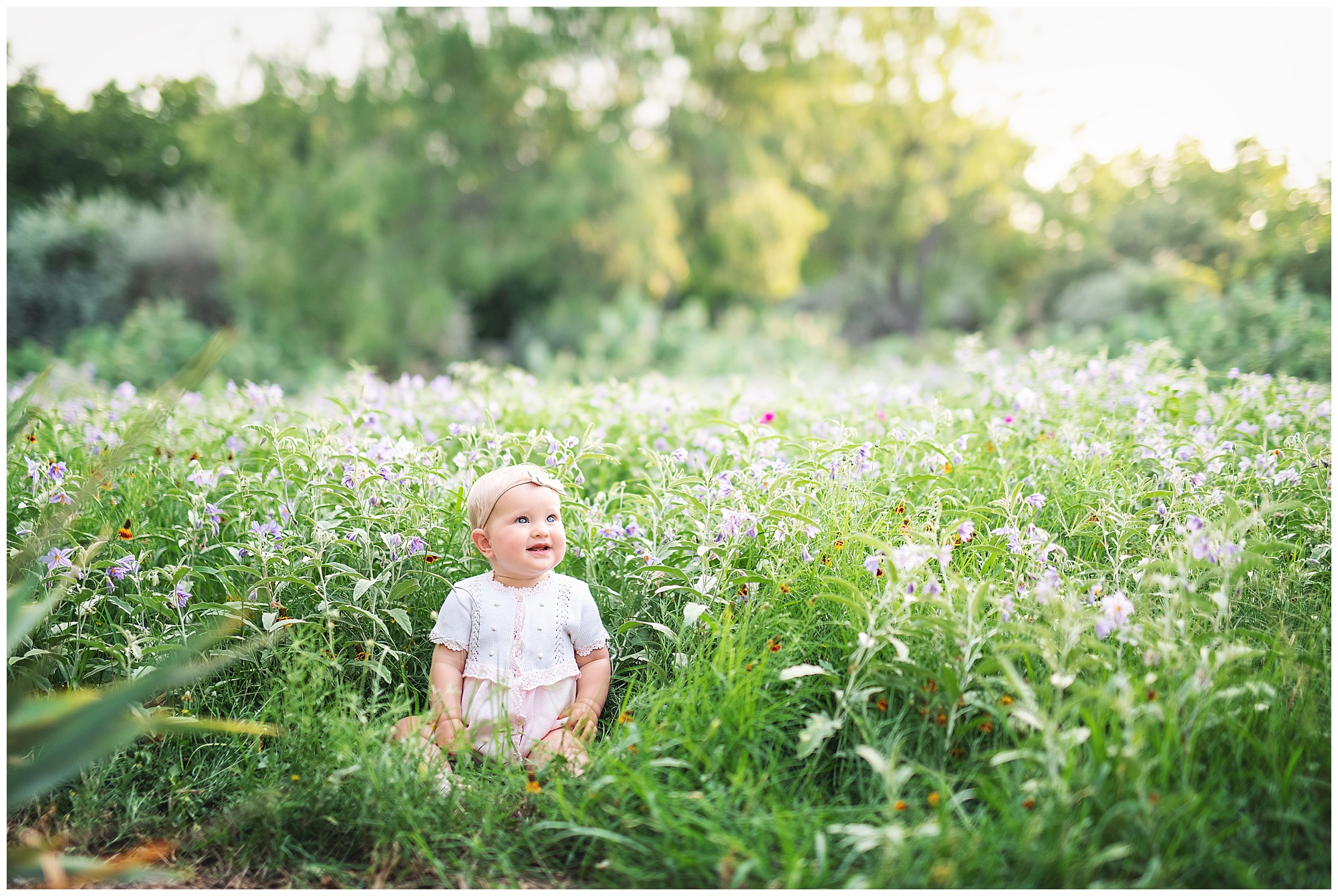 little girl in a sea of wildflowers smiling happily!