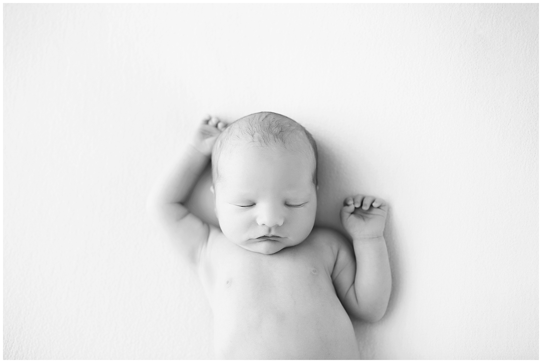 newborn boy stretching in black and white