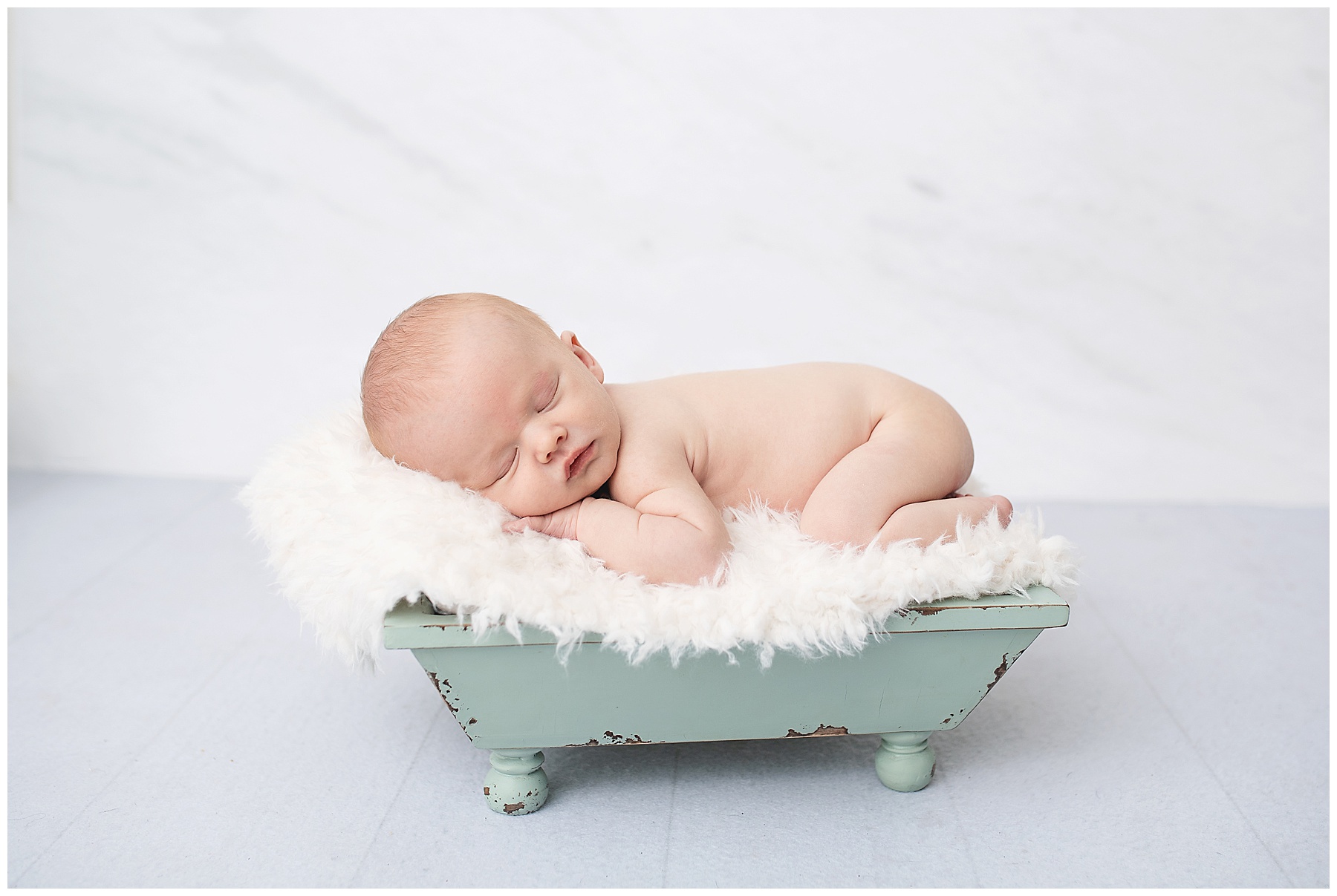 newborn photos and baby boy is laying on a bucket